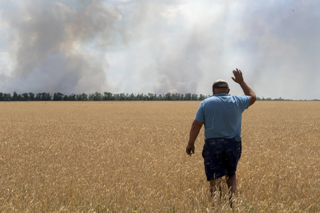 A farmer looks at his burning field caused by the fighting in the Dnipropetrovsk region of Ukraine. AP