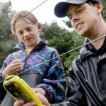 Farm manager Sam Waugh shows Finn Grant from Nina Busing Kindergarten and home-school pupil Sky Ryan how to check the voltage on the electric fence.