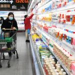 Consumers browse dairy products at a supermarket in Shijiazhuang, Hebei province, on Dec 9, 2021.