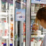 In this Dec. 4, 2013, file photo Jessica Walton, of Guthrie, Okla., reaches for a container of milk at a grocery store in Edmond, Okla. On Tuesday, Nov. 12, 2019, Dean Foods, the nation's largest milk processor, filed for Chapter 11 bankruptcy protection and said it may sell the company off to the Dairy Farmers of America.