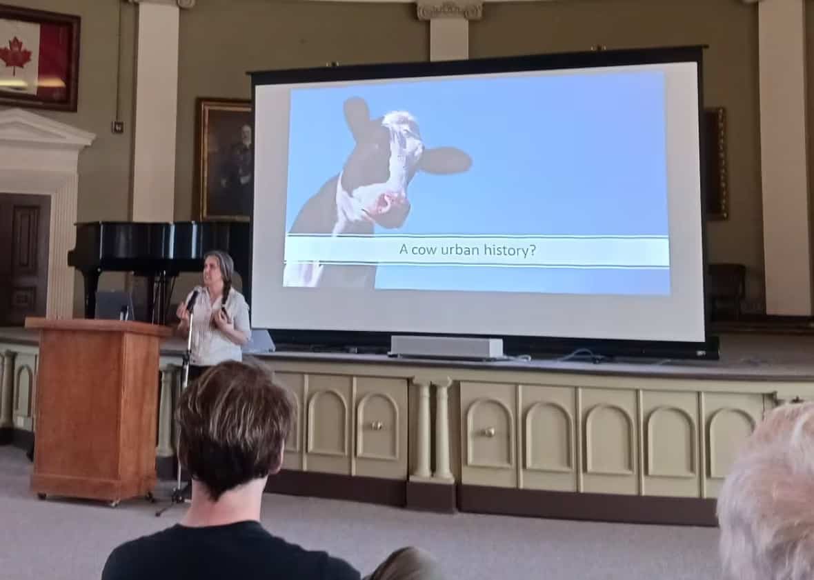 Queen's PhD candidate and urban geographer Claudia Hirtenfelder gives a lecture about the history of urban cows in Kingston on April 20.