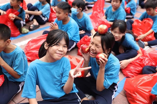 Children under the care of the Maison Chance charity enjoying their new fruit gifts. — Photo courtesy of the New Zealand Embassy in Việt Nam